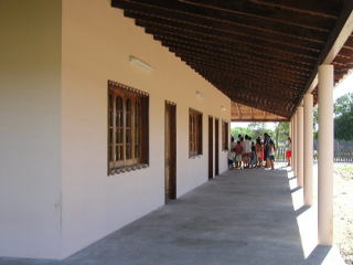 清楚で堅牢な壁、窓、柱、廊下。深い軒下は強い風雨から教室を守る役目も